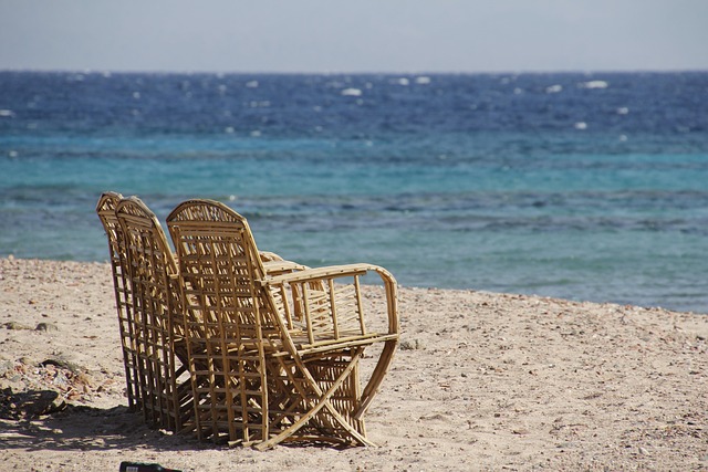 obrazek wakacyjny, dwa fotele na plaży skierowane w stronę morza