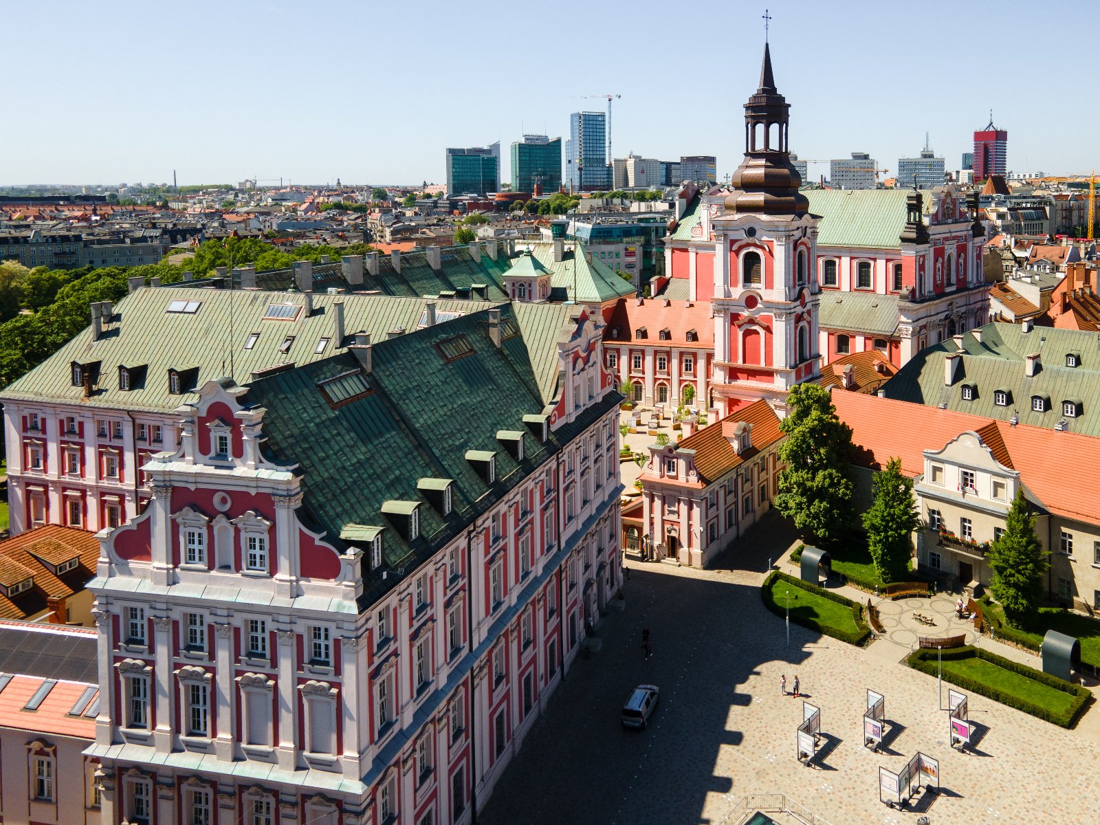 Panorama Poznania z lotu ptaka przedstawiająca barokowy zespół pojezuicki z Bazyliką Kolegiacką i Urzędem Miasta oraz placem Kolegiackim w słoneczny dzień.