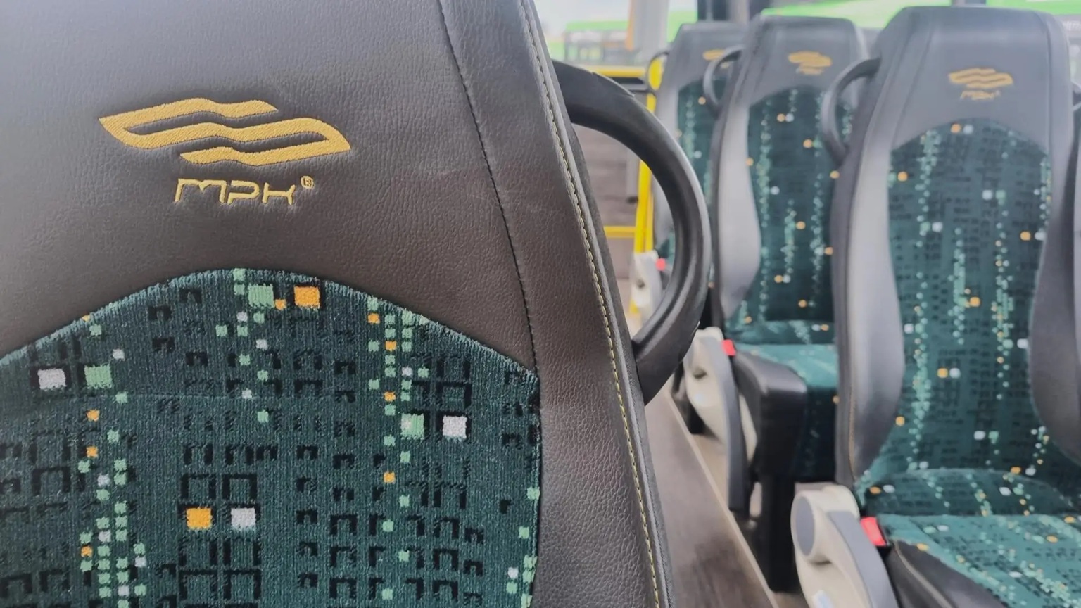Poglądowe zdjęcie siedzeń w minibusie innej marki. Widać logo MPK