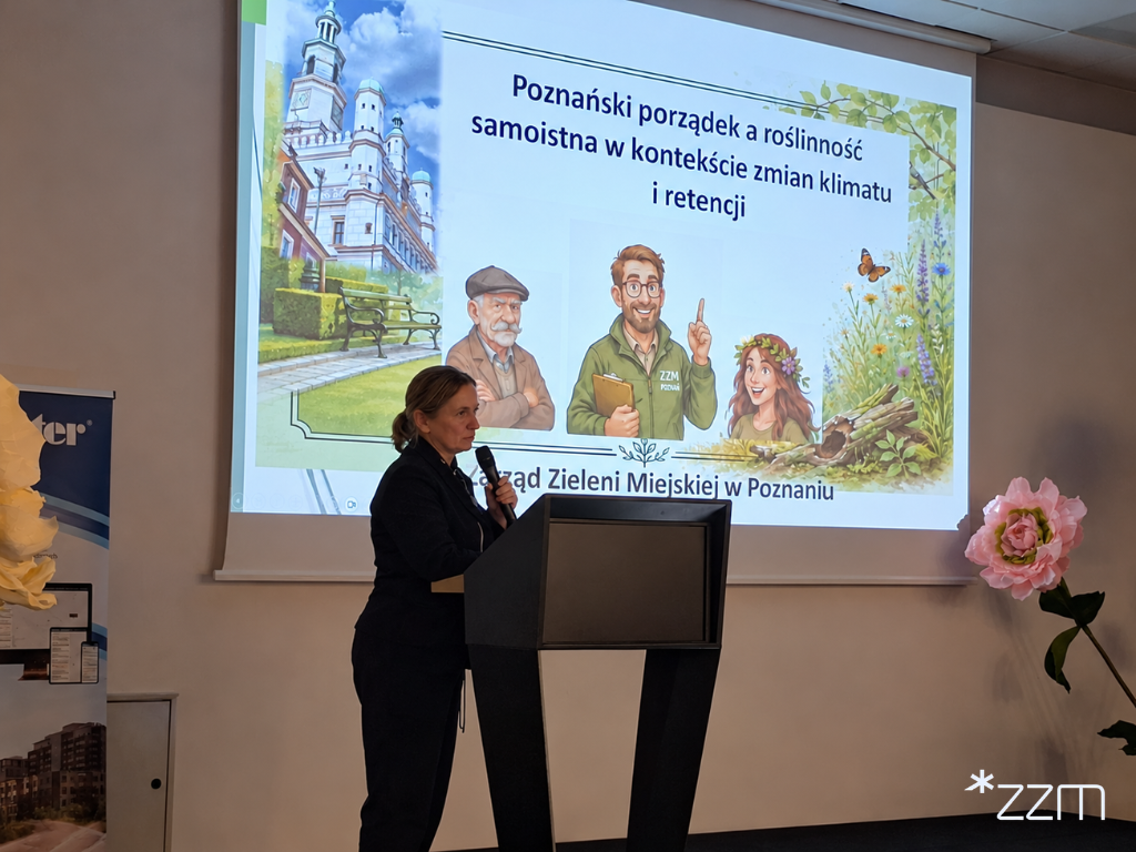Przedstawicielka Zarządu Zieleni Miejskiej w Poznaniu stoi przy mównicy z mikrofonem w dłoni. Za nią wyświetlany jest slajd z tytułem prezentacji: "Poznański porządek a roślinność samoistna w kontekście zmian klimatu i retencji", zilustrowany poznańskim ratuszem, postaciami i roślinami.