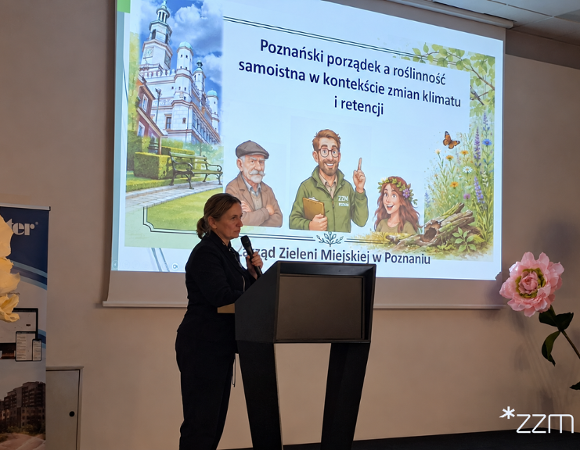Przedstawicielka Zarządu Zieleni Miejskiej w Poznaniu stoi przy mównicy z mikrofonem w dłoni. Za nią wyświetlany jest slajd z tytułem prezentacji: "Poznański porządek a roślinność samoistna w kontekście zmian klimatu i retencji", zilustrowany poznańskim ratuszem, postaciami i roślinami.