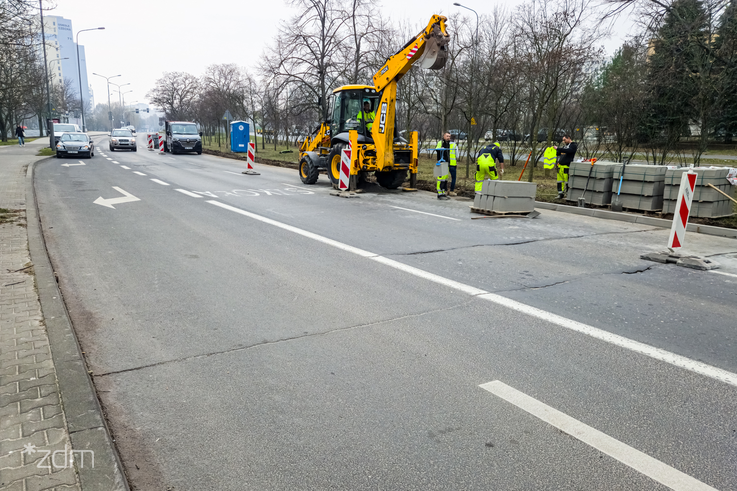 Robotnicy przy żółtym ciągniku na remontowanej ul. Chartowo