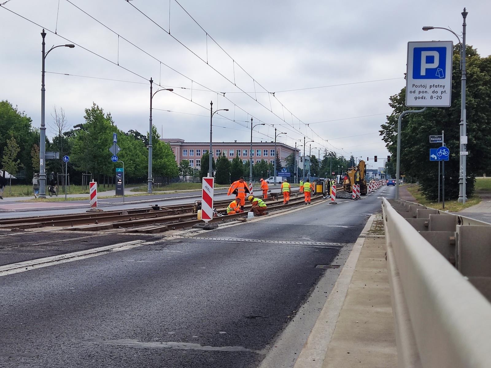 Zdjęcie prac przy remoncie torowiska przy ul. Kórnickiej, rovbotnicy pracuja na torach przy zwężonej jezdni