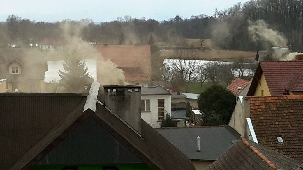 Zdjęcie przedstawia domy jednorodzinne i gęsty dym unoszący się z kominów