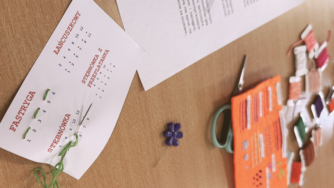 Zdjęcie przedstawia materiał oraz tamborek potrzebny do wyszywania na ubraniu, zdjęcie zostało wykonane na warsztatach z haftu na ubraniach